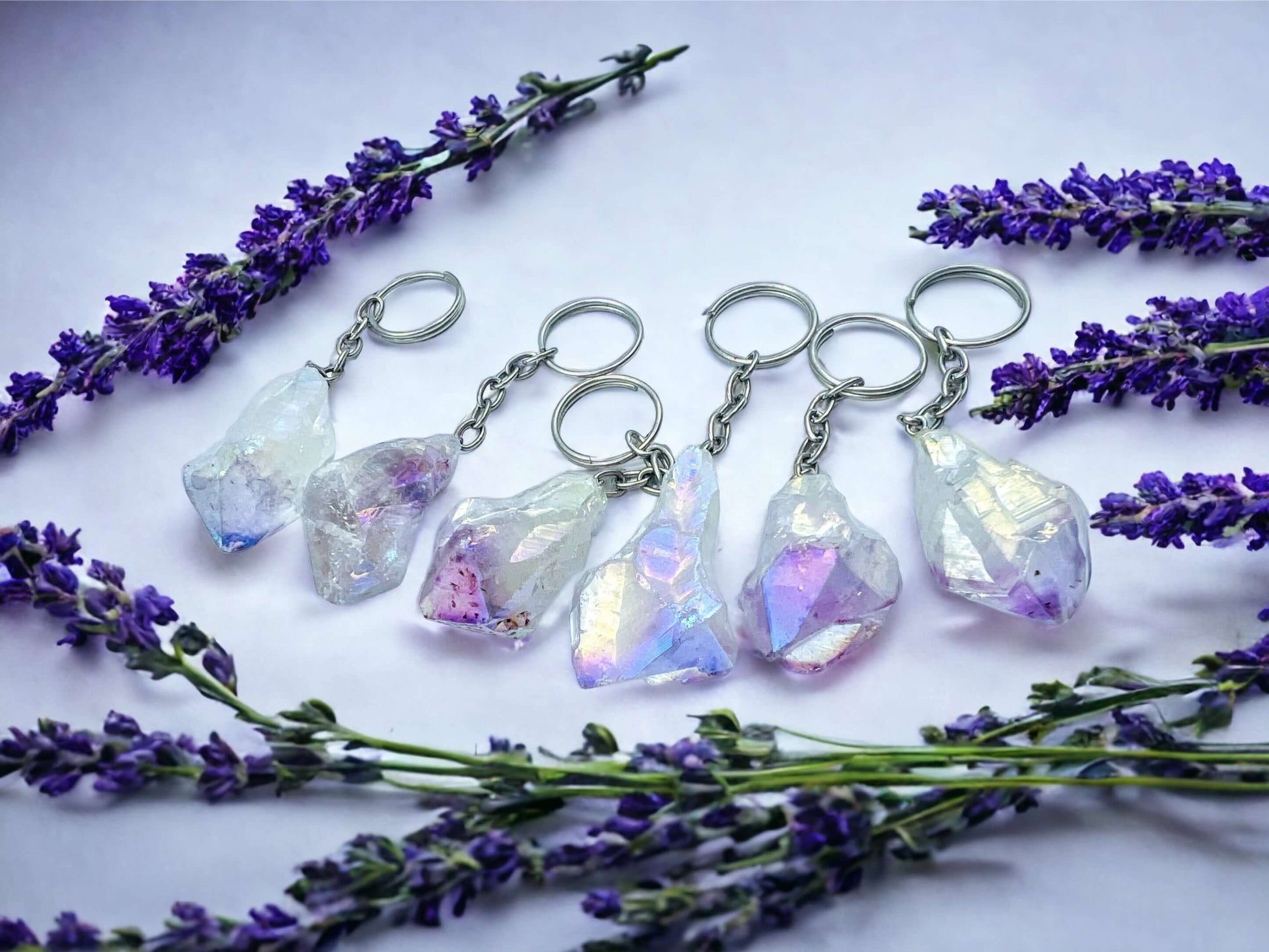 Crystal key rings on white surface with petals